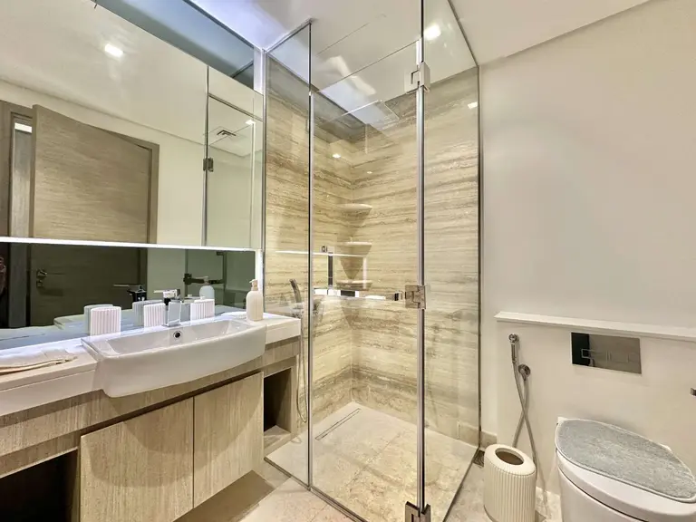 En-suite bathroom with a glass shower enclosure and stone-look walls