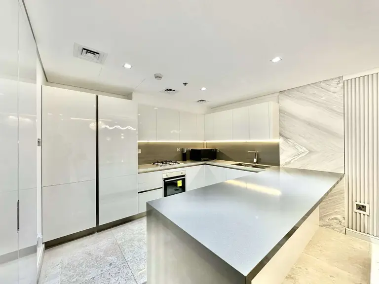 White gloss kitchen with a grey island and full-height cabinets