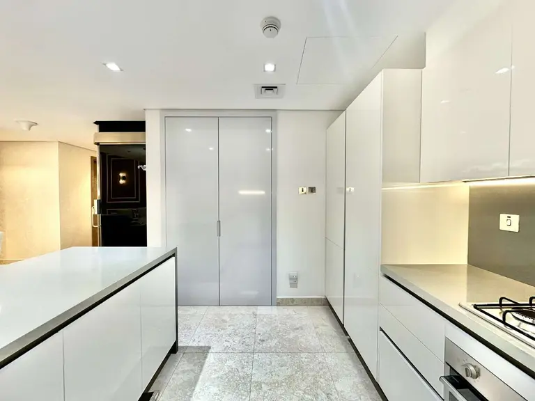 Kitchen with an island, tall cabinets and a gas hob