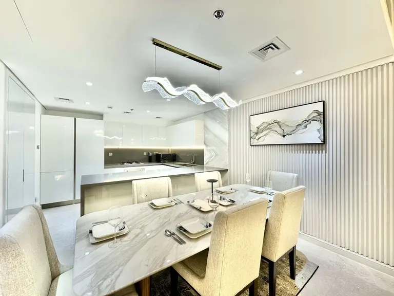 Dining table set for six beside a fluted wall panel