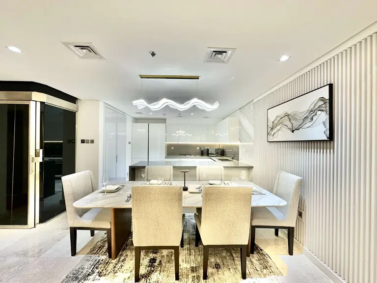 Dining area with upholstered chairs and a view into the kitchen