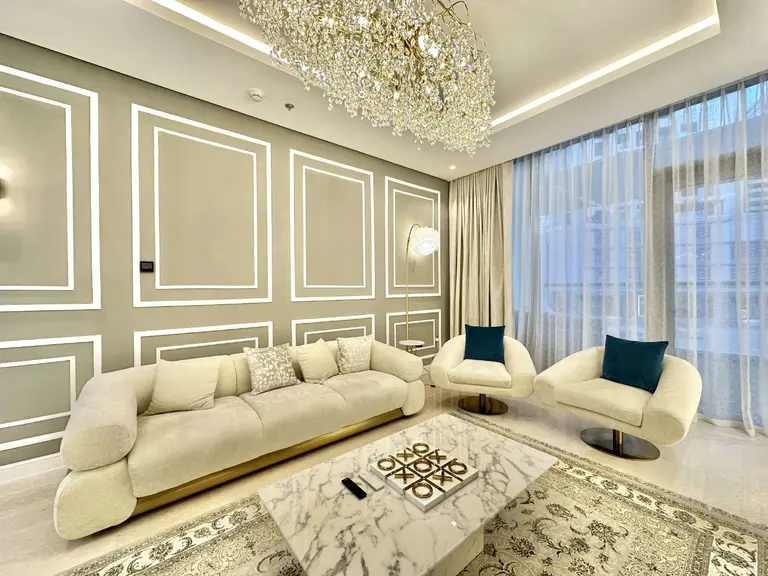 Panelled living room with sheer curtains and swivel armchairs